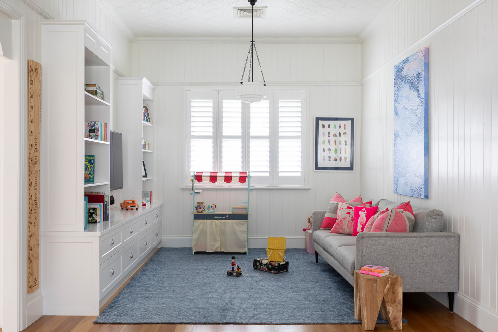 Exempel på ett mellanstort modernt barnrum kombinerat med lekrum, med vita väggar, ljust trägolv och brunt golv