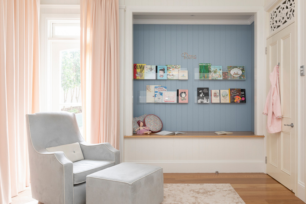 Diseño de dormitorio infantil de 1 a 3 años clásico renovado grande con paredes azules, suelo de madera clara, suelo marrón y panelado