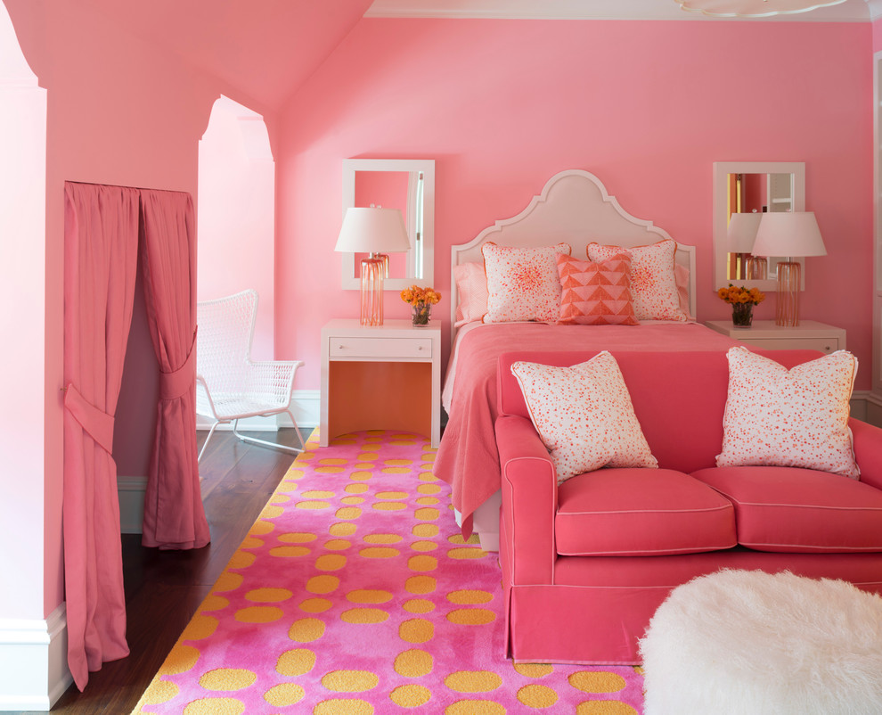 Cette image montre une grande chambre d'enfant traditionnelle avec un mur rose et parquet foncé.