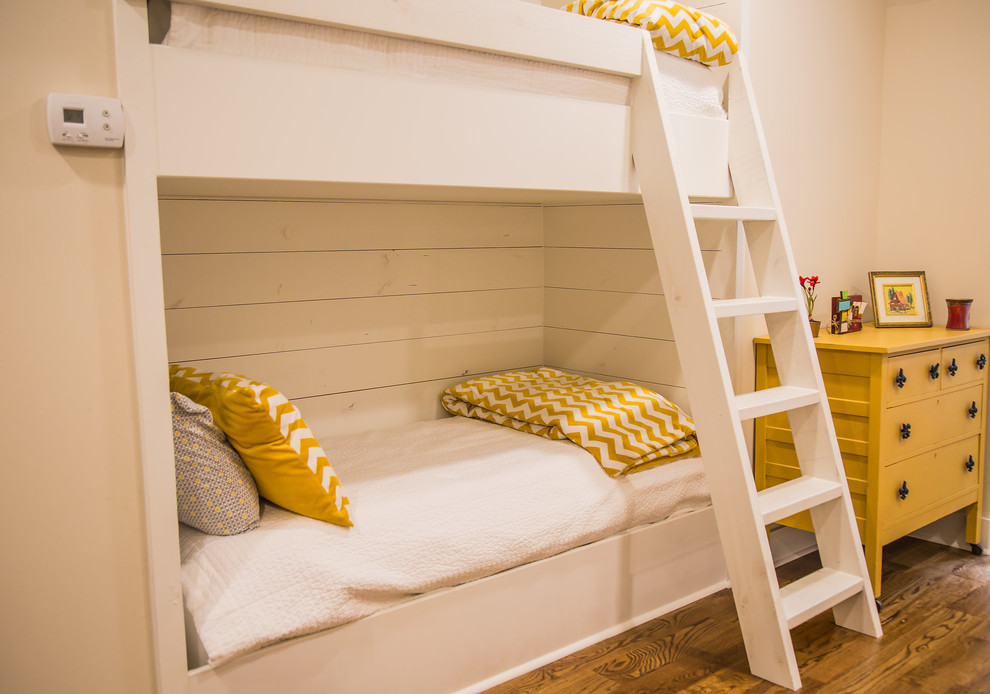 Modelo de dormitorio infantil de 4 a 10 años de tamaño medio con paredes blancas, suelo de madera en tonos medios y suelo beige