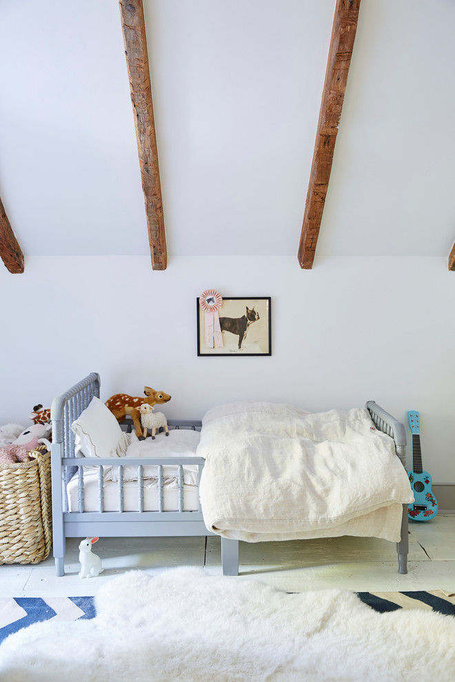Bild på ett lantligt barnrum kombinerat med sovrum, med vita väggar, målat trägolv och vitt golv