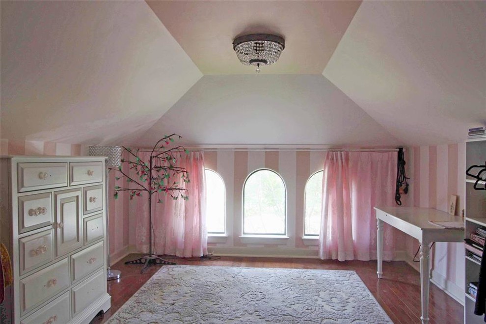 Expansive mediterranean kids' bedroom for girls in Houston with pink walls, medium hardwood flooring and brown floors.