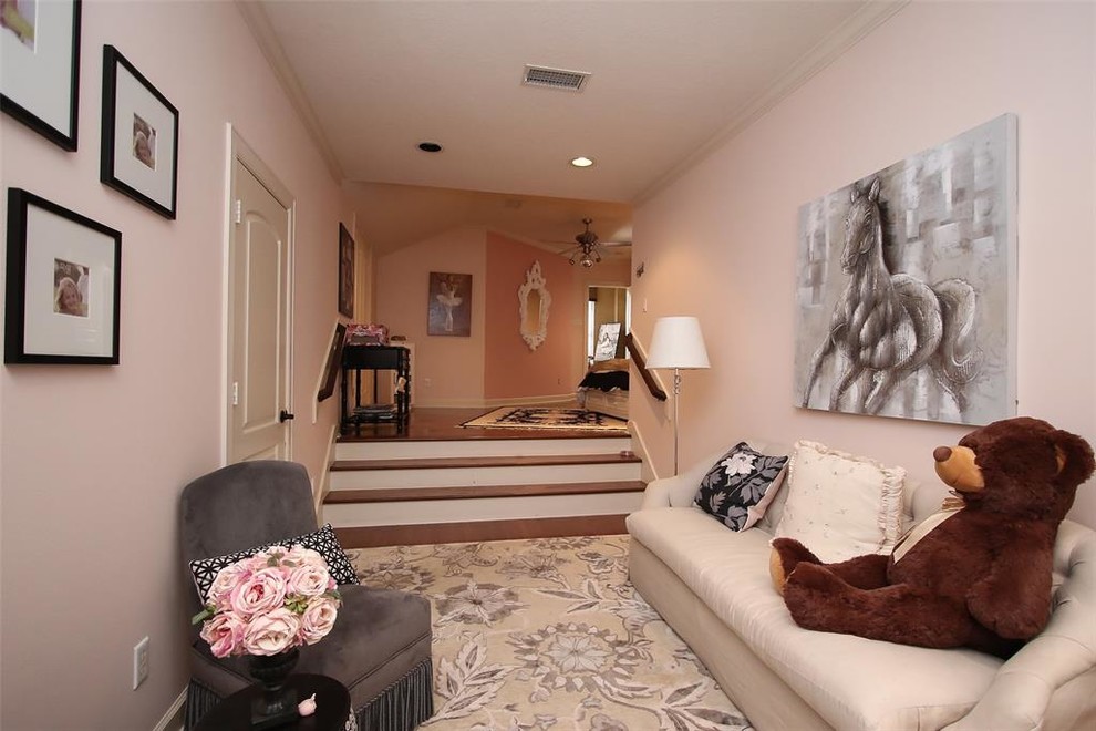 Photo of an expansive mediterranean kids' bedroom for girls in Houston with dark hardwood flooring, brown floors and pink walls.