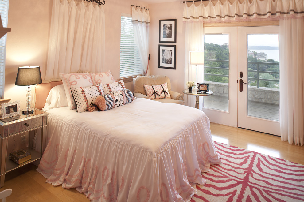 Immagine di una cameretta per bambini da 4 a 10 anni tradizionale di medie dimensioni con pareti rosa e parquet chiaro