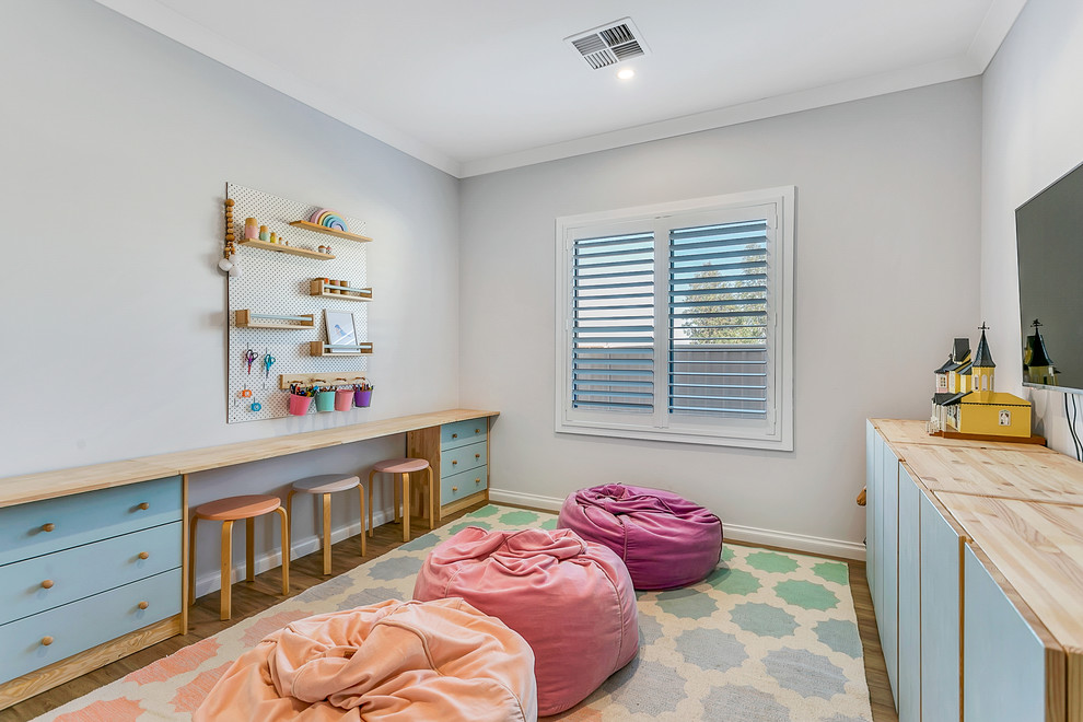 Idéer för ett modernt könsneutralt barnrum kombinerat med lekrum och för 4-10-åringar, med grå väggar, mellanmörkt trägolv och brunt golv