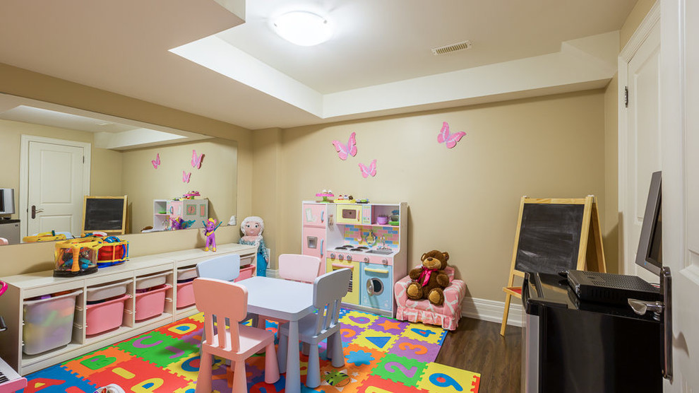 Large traditional kids' bedroom for girls in Toronto with pink walls and dark hardwood flooring.