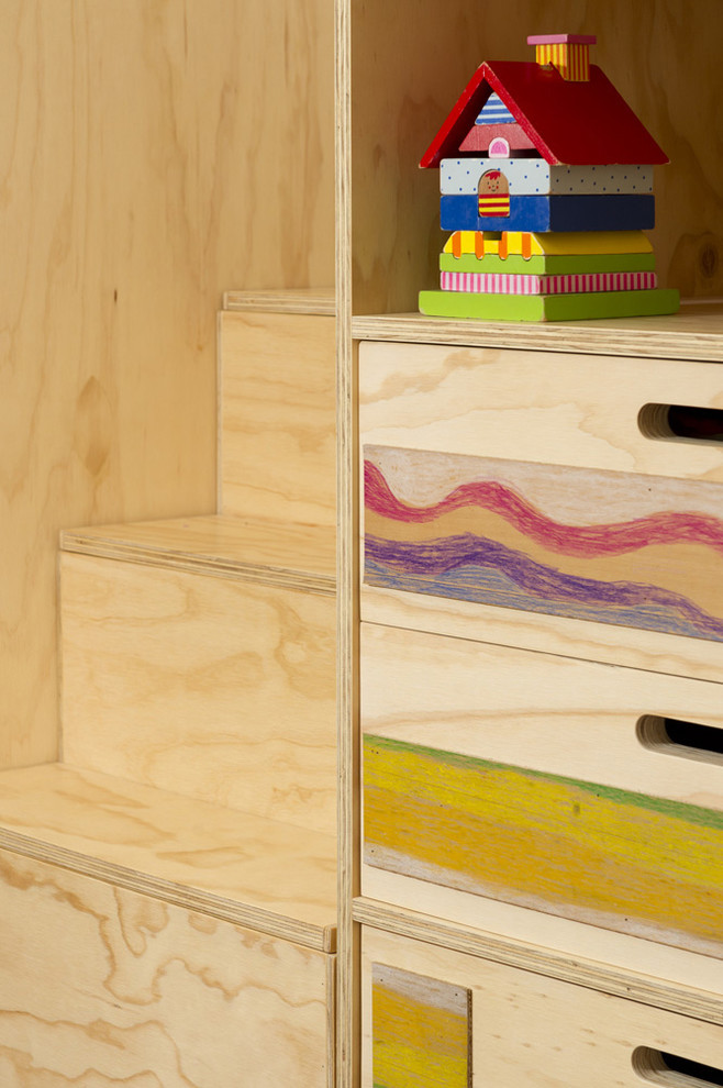 Esempio di una piccola cameretta per bambini da 4 a 10 anni minimalista con pareti bianche e pavimento in legno massello medio