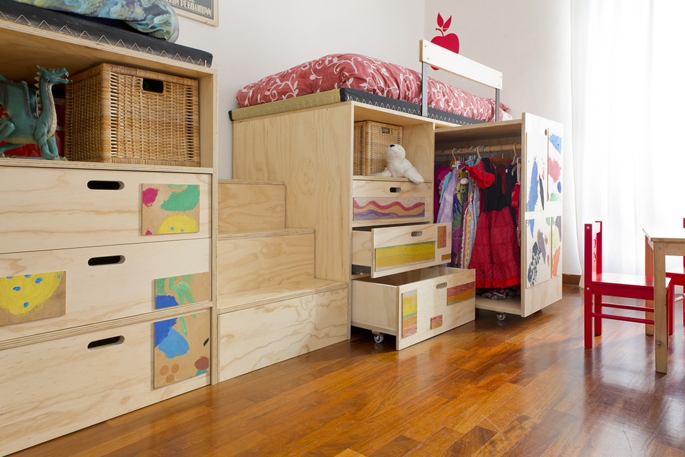 Cette image montre une petite chambre d'enfant de 4 à 10 ans minimaliste avec un mur blanc et un sol en bois brun.