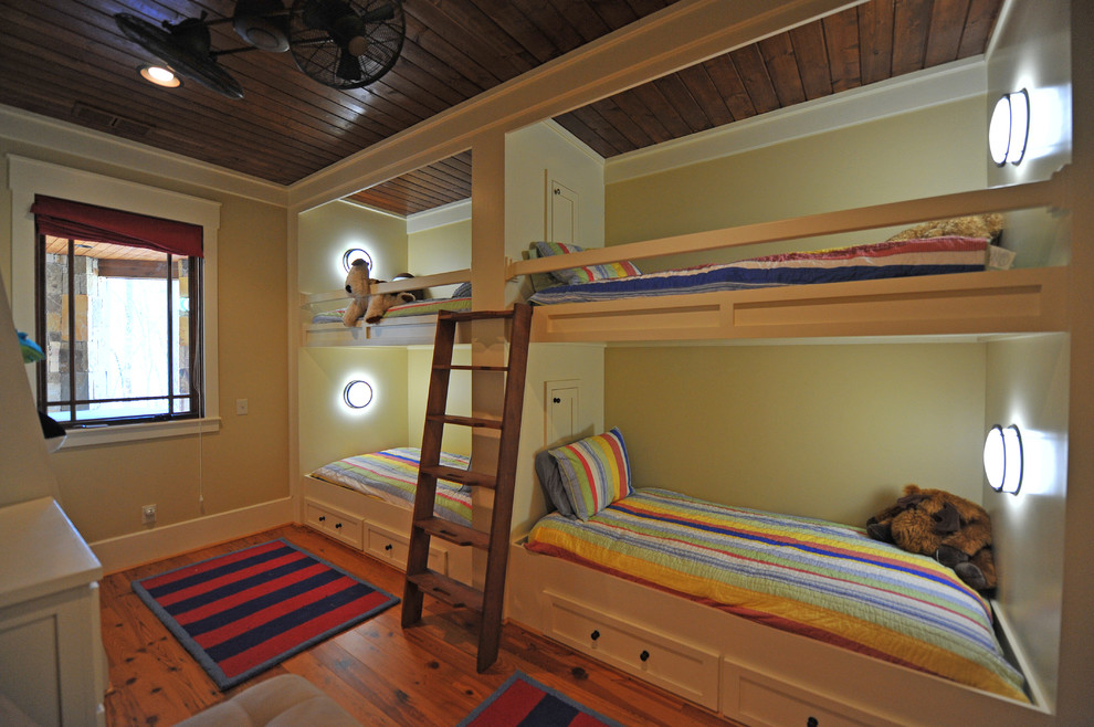 Rustik inredning av ett könsneutralt barnrum kombinerat med sovrum och för 4-10-åringar, med mellanmörkt trägolv och gula väggar