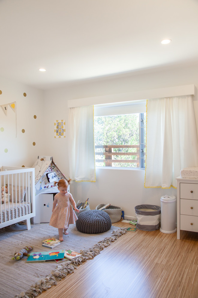 Foto di una cameretta da bambina da 1 a 3 anni minimalista con pareti bianche e parquet chiaro
