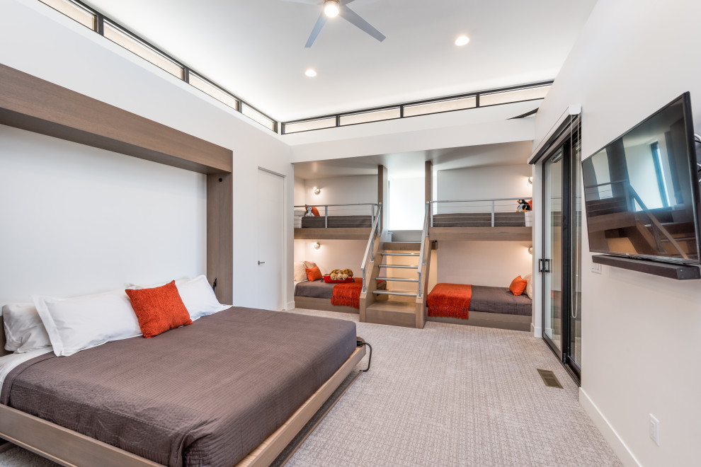 Exempel på ett stort modernt könsneutralt barnrum kombinerat med sovrum, med vita väggar, heltäckningsmatta och grått golv