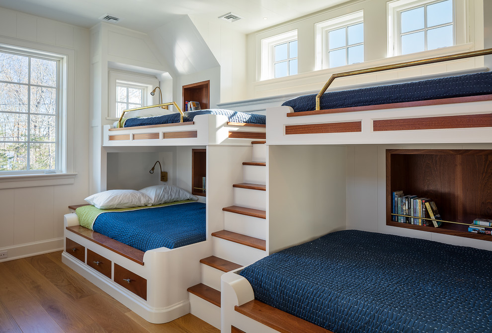 Aménagement d'une chambre d'enfant bord de mer avec un mur blanc, un sol en bois brun, un sol marron et un lit superposé.