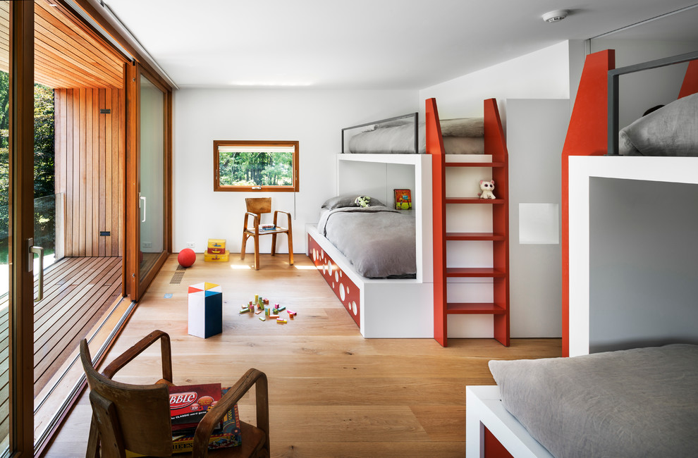 Cette photo montre une chambre d'enfant tendance avec un mur blanc et parquet clair.