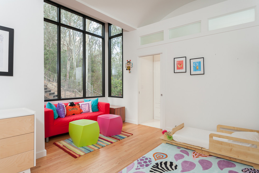 Inspiration för ett funkis könsneutralt småbarnsrum kombinerat med sovrum, med vita väggar och ljust trägolv