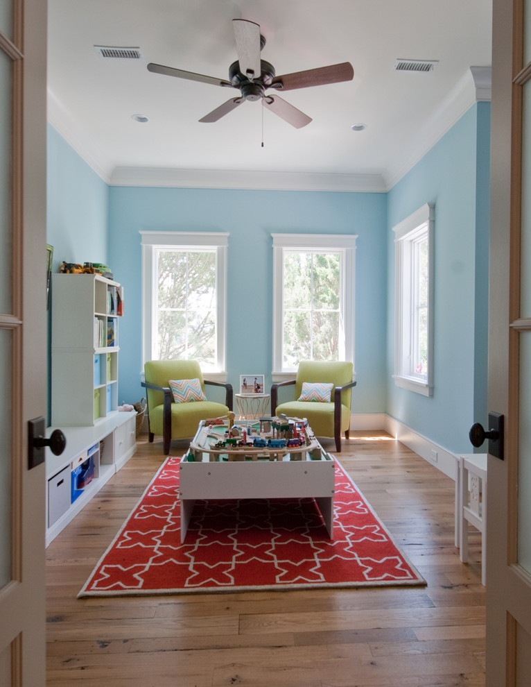Mid-sized island style gender-neutral medium tone wood floor kids' room photo in Charleston with blue walls