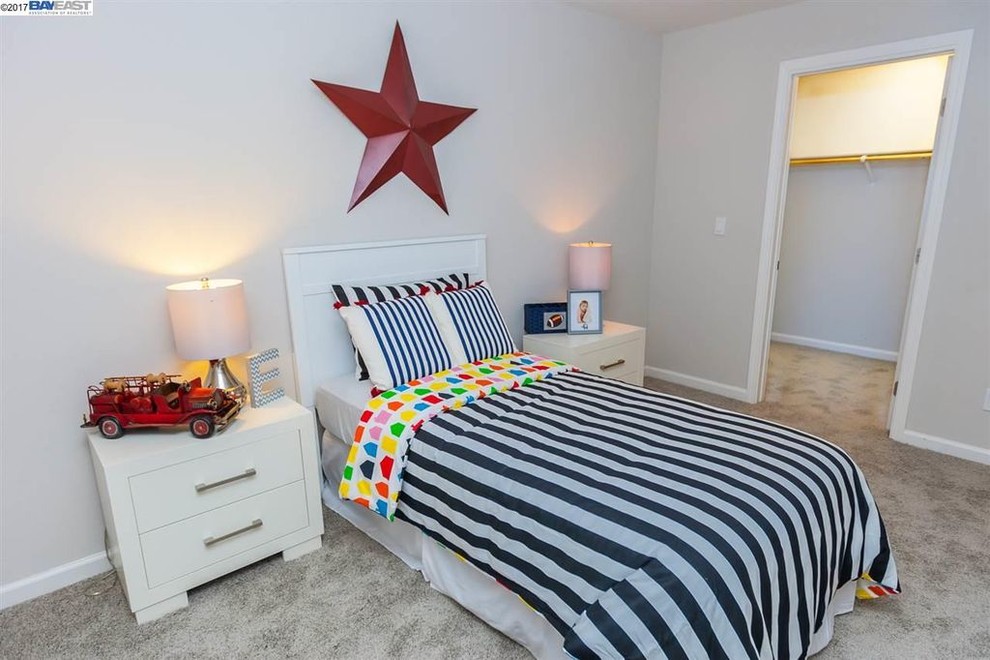 Imagen de dormitorio infantil de 4 a 10 años minimalista de tamaño medio con paredes beige, moqueta y suelo beige