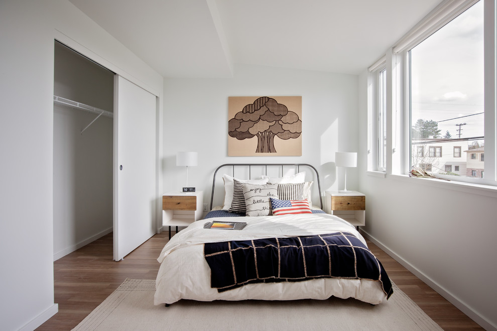 Imagen de dormitorio infantil actual con paredes blancas, suelo de madera en tonos medios y suelo marrón