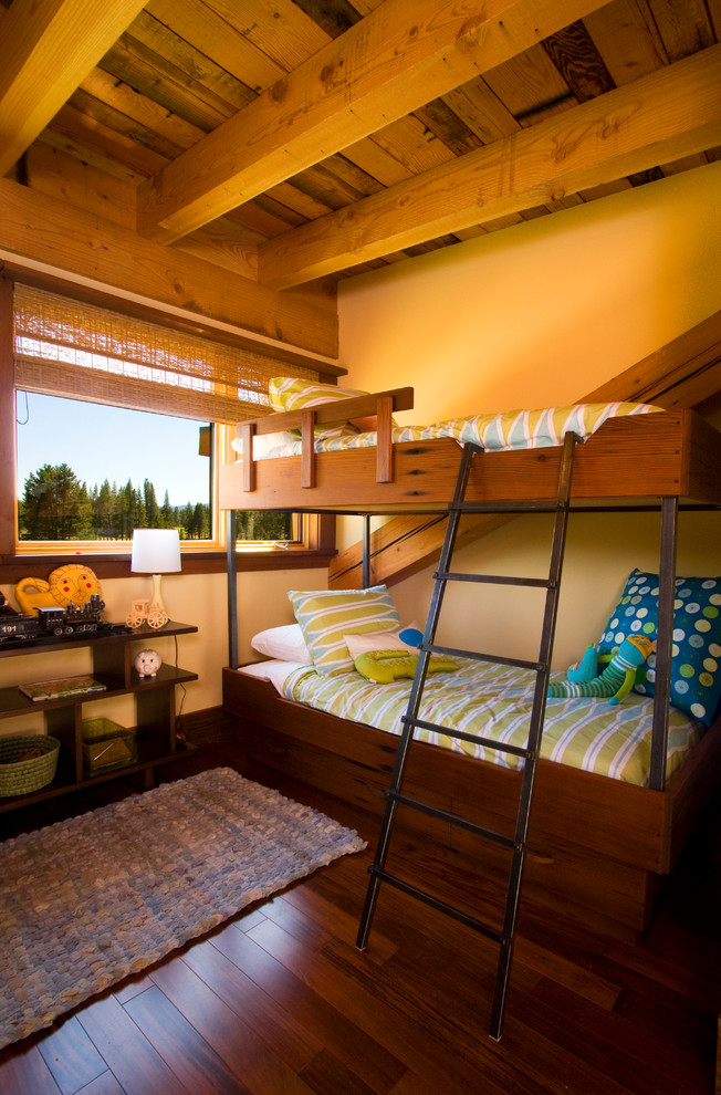На фото: нейтральная детская в стиле рустика с спальным местом, желтыми стенами и темным паркетным полом для ребенка от 1 до 3 лет, двоих детей с