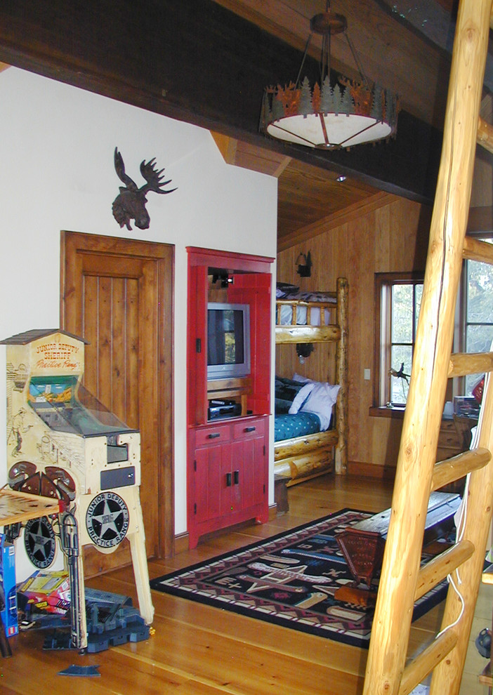 Ejemplo de dormitorio infantil rural de tamaño medio con suelo de madera en tonos medios