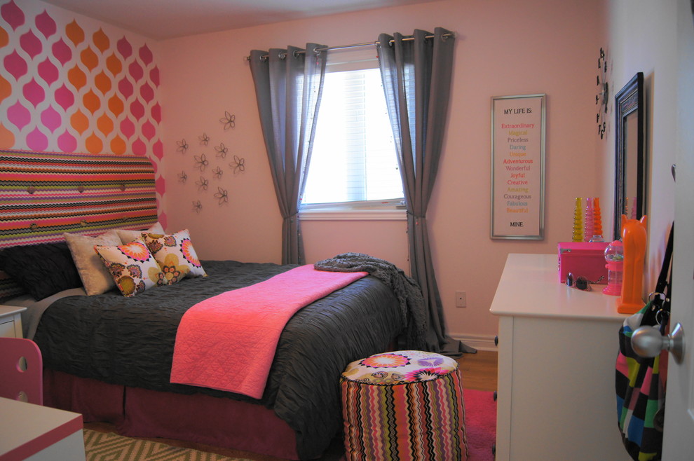 Esempio di una cameretta per bambini minimal di medie dimensioni con pareti rosa e pavimento in legno massello medio