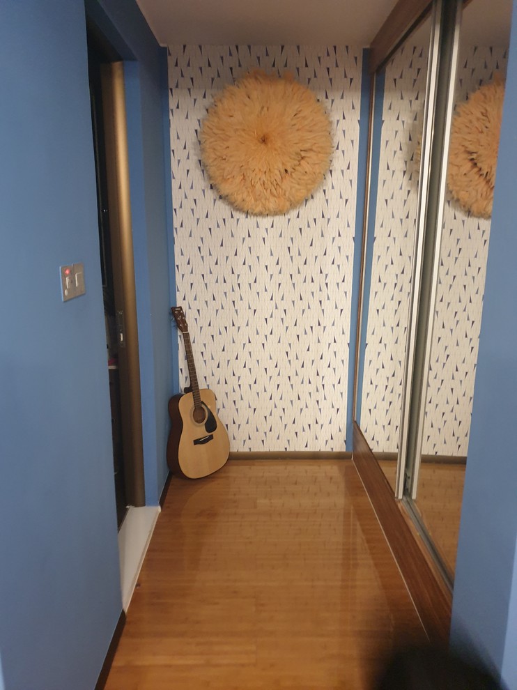 Modelo de dormitorio infantil moderno de tamaño medio con paredes azules y suelo laminado
