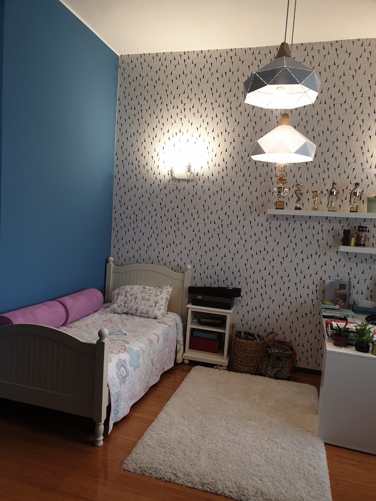 Cette photo montre une chambre d'enfant moderne de taille moyenne avec un mur bleu et sol en stratifié.