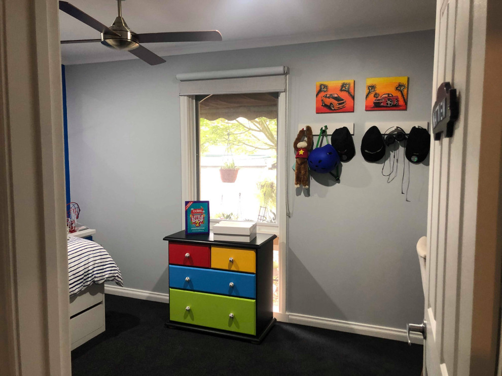 Inredning av ett modernt mellanstort barnrum kombinerat med sovrum, med grå väggar, heltäckningsmatta och grått golv