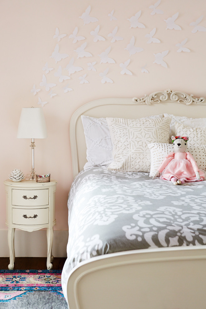 Inredning av ett klassiskt stort flickrum kombinerat med sovrum och för 4-10-åringar, med rosa väggar och mörkt trägolv