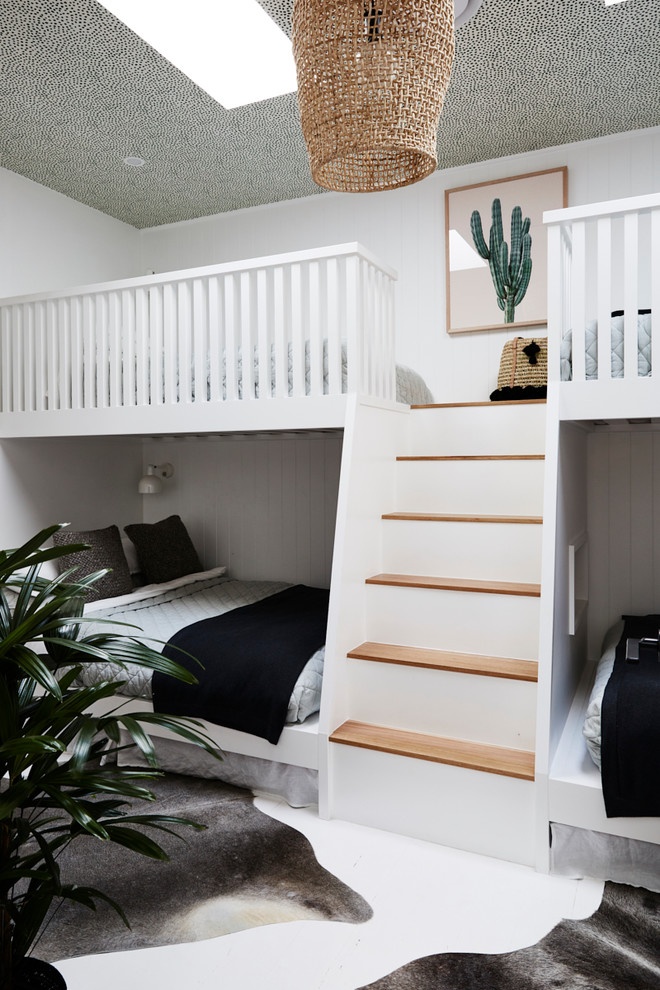 Inredning av ett modernt mellanstort könsneutralt barnrum kombinerat med sovrum och för 4-10-åringar, med vita väggar, målat trägolv och vitt golv