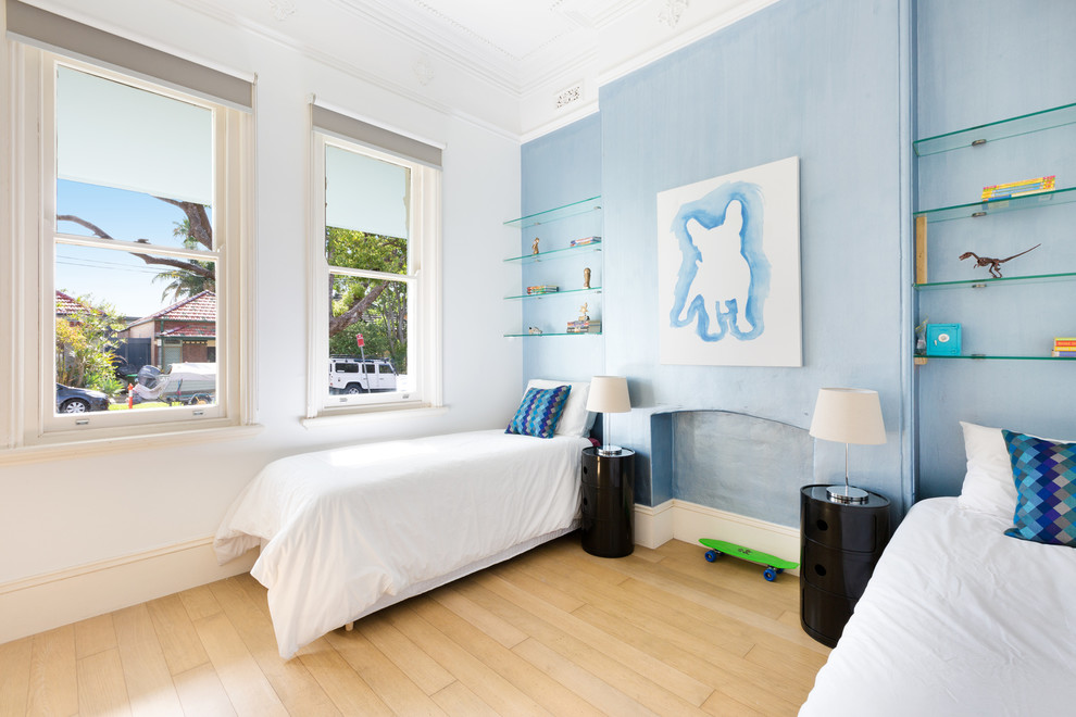 Aménagement d'une chambre d'enfant de 4 à 10 ans contemporaine avec un mur bleu et parquet clair.