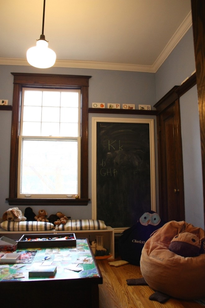 Inspiration pour une chambre d'enfant de 1 à 3 ans bohème avec un mur bleu et un sol en bois brun.