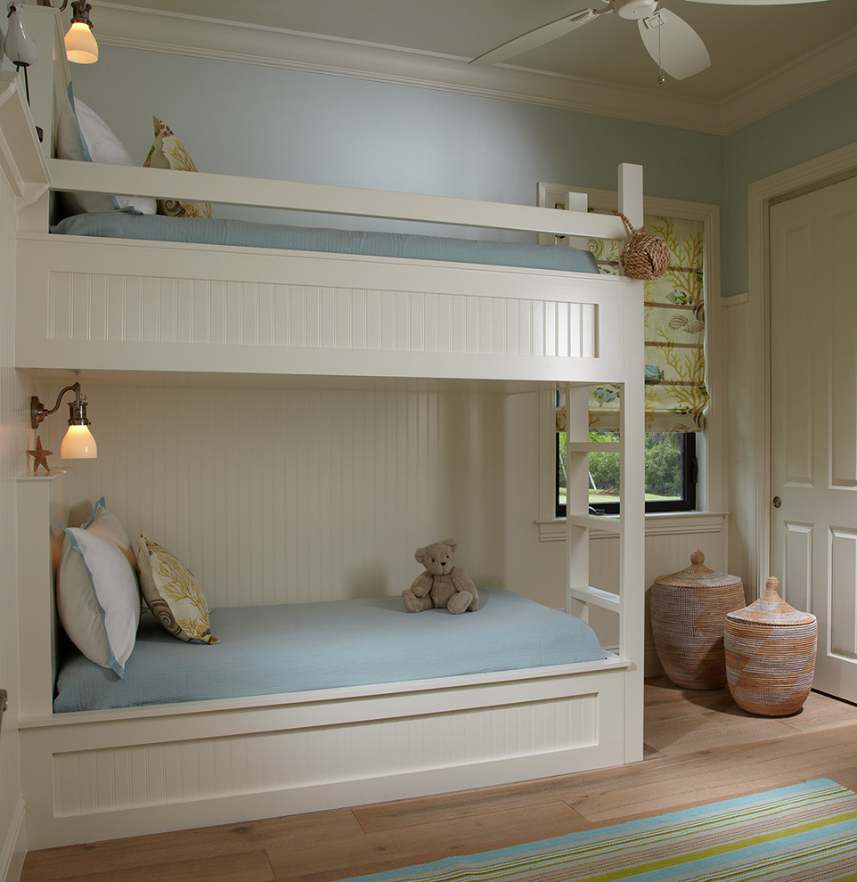 На фото: нейтральная детская в морском стиле с спальным местом, синими стенами и светлым паркетным полом для ребенка от 4 до 10 лет с