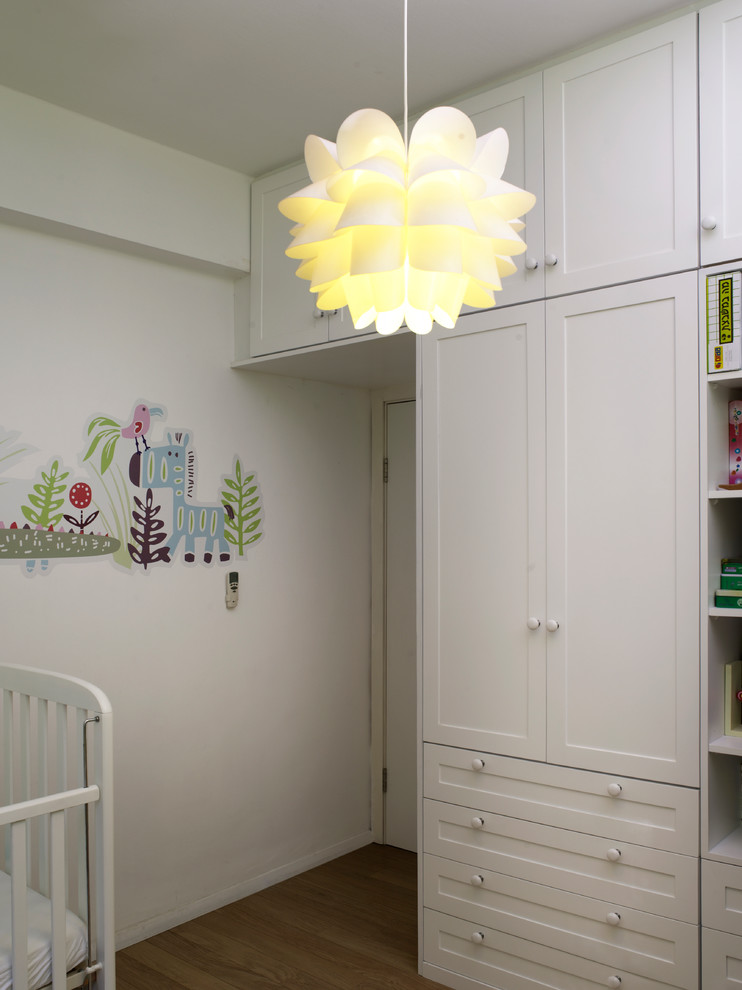 Ispirazione per una piccola cameretta per bambini da 4 a 10 anni design con parquet chiaro e pareti bianche