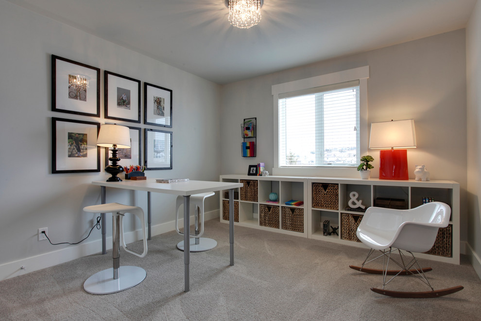 Idéer för ett mellanstort klassiskt könsneutralt tonårsrum kombinerat med skrivbord, med grå väggar och heltäckningsmatta