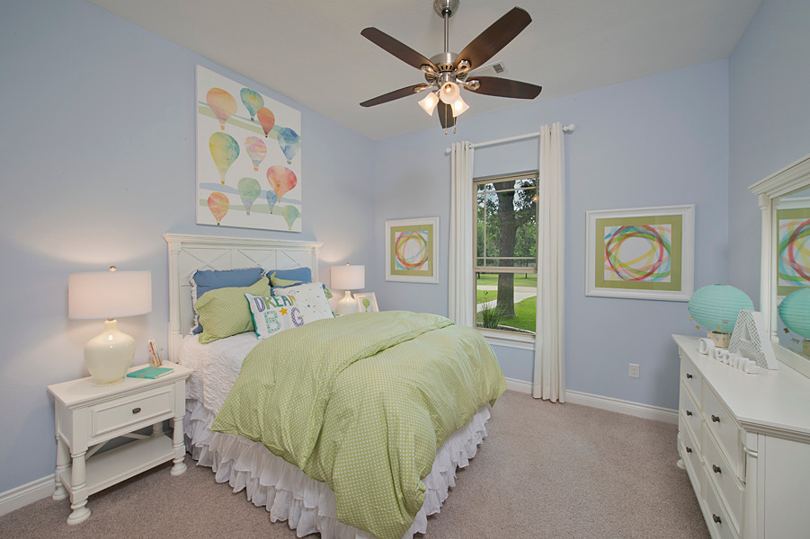 Mittelgroßes Landhaus Mädchenzimmer mit Schlafplatz, blauer Wandfarbe, Teppichboden und braunem Boden in Houston
