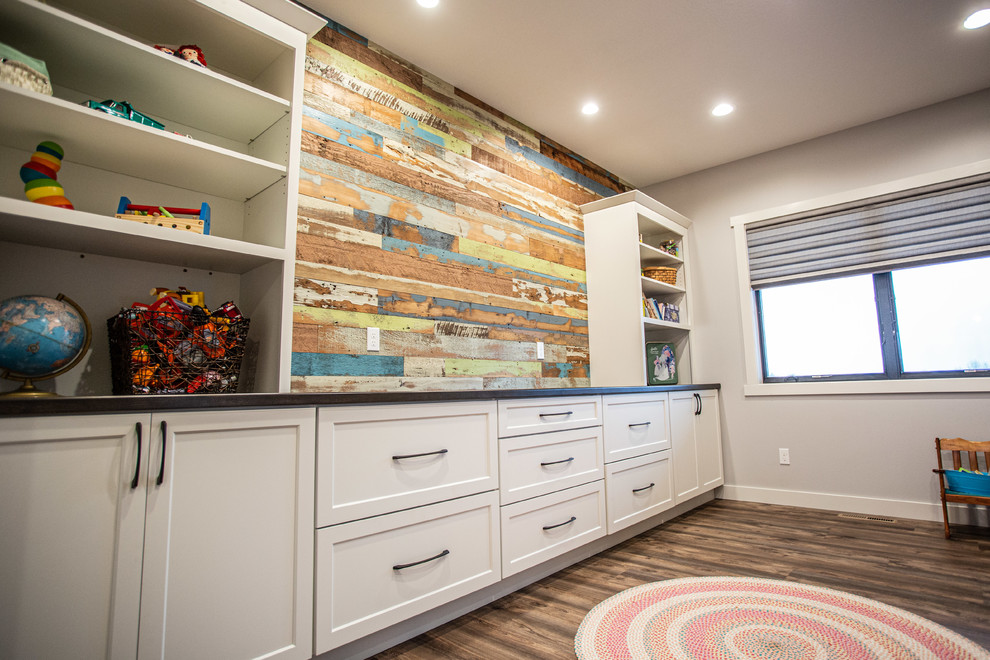 Exemple d'une grande chambre d'enfant de 1 à 3 ans nature avec un mur multicolore, un sol en vinyl et un sol marron.