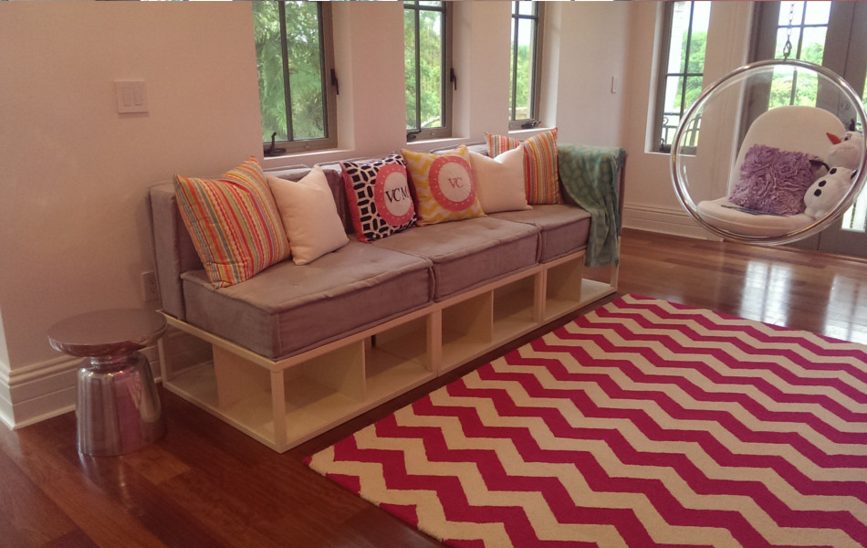 Foto di una piccola cameretta per bambini design con pareti rosa, pavimento in legno massello medio e pavimento marrone