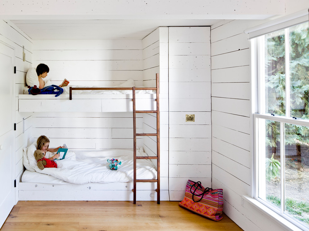 Country gender-neutral medium tone wood floor kids' room photo in Portland with white walls