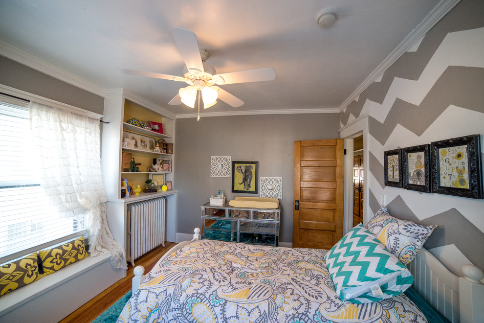 Ejemplo de dormitorio infantil de 1 a 3 años clásico renovado pequeño con paredes grises y suelo de madera en tonos medios
