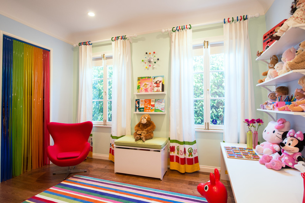 Ejemplo de dormitorio infantil actual con paredes verdes y suelo de madera en tonos medios
