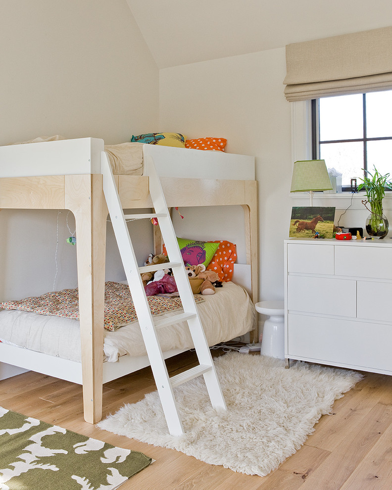 Imagen de dormitorio infantil de 4 a 10 años actual con paredes beige y suelo de madera clara
