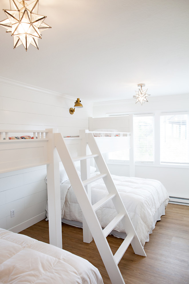 Imagen de dormitorio infantil de 4 a 10 años costero grande con paredes blancas y suelo de madera en tonos medios
