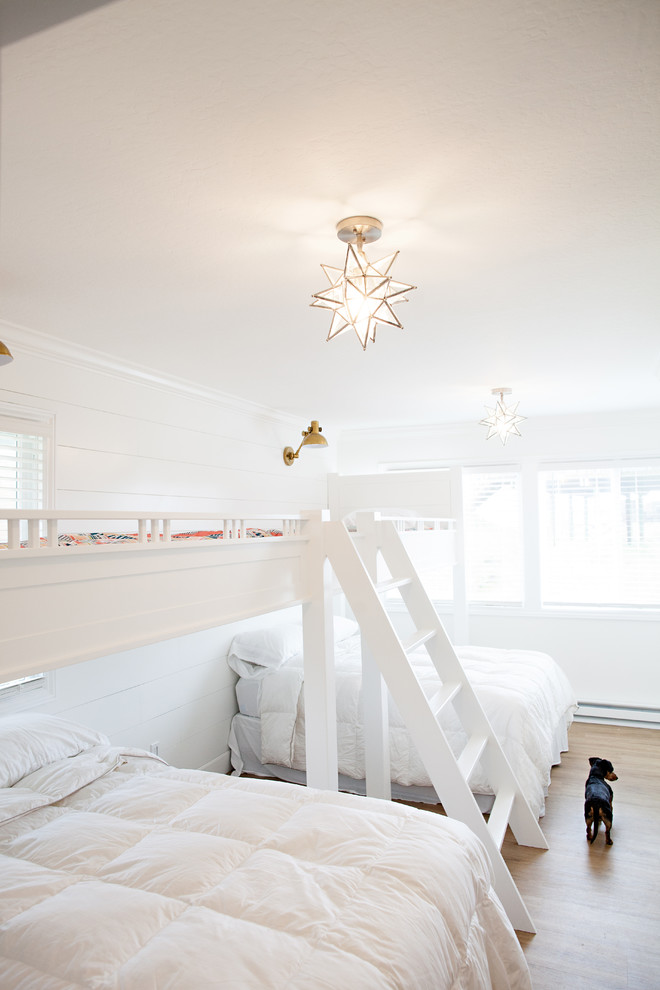 Immagine di una grande cameretta per bambini da 4 a 10 anni stile marino con pareti bianche e pavimento in legno massello medio