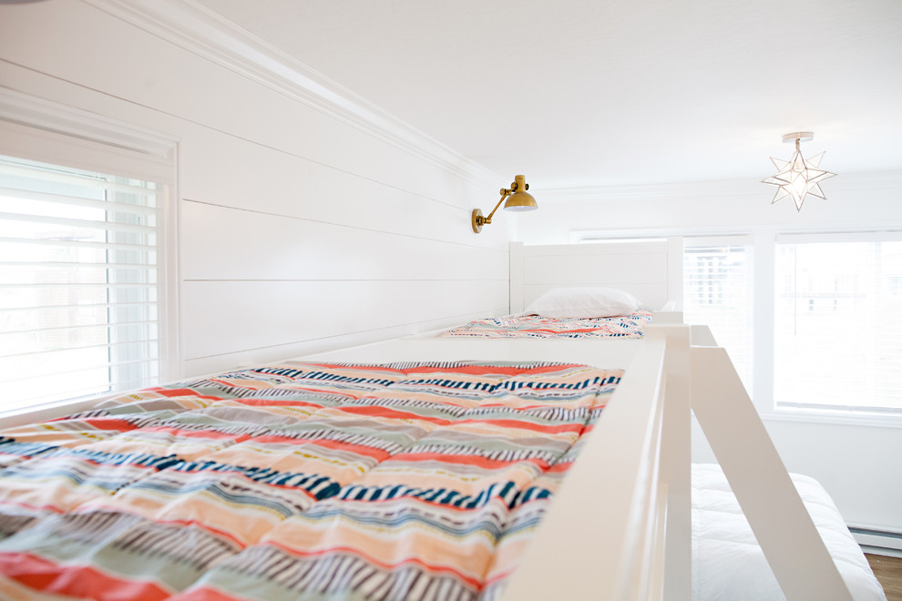 Ejemplo de dormitorio infantil de 4 a 10 años costero grande con paredes blancas y suelo de madera en tonos medios