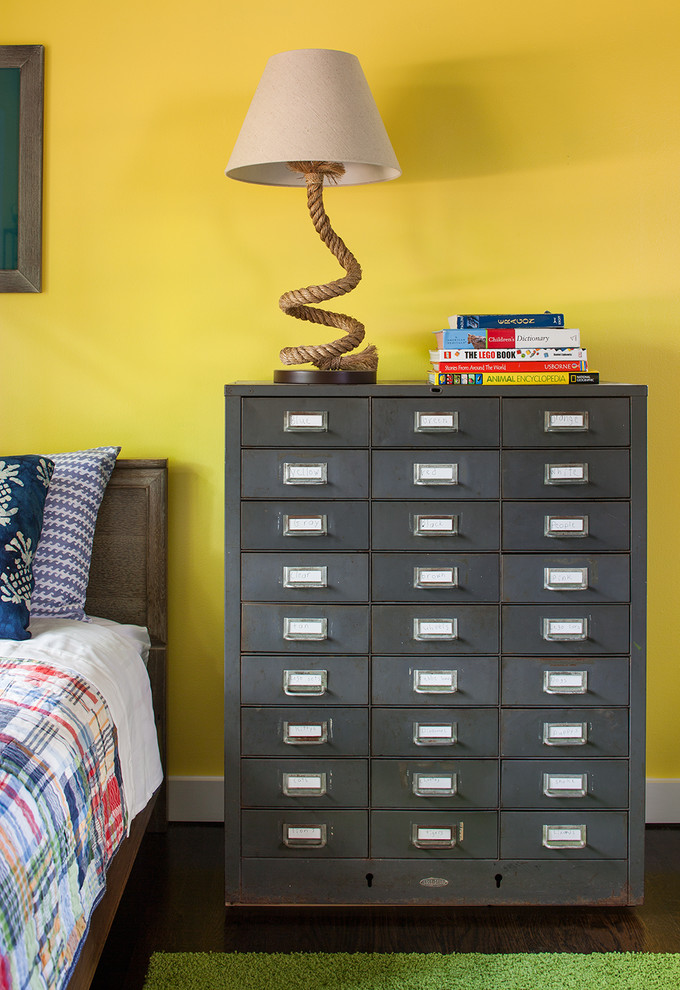 This is an example of a classic children’s room for boys in Atlanta with yellow walls and dark hardwood flooring.