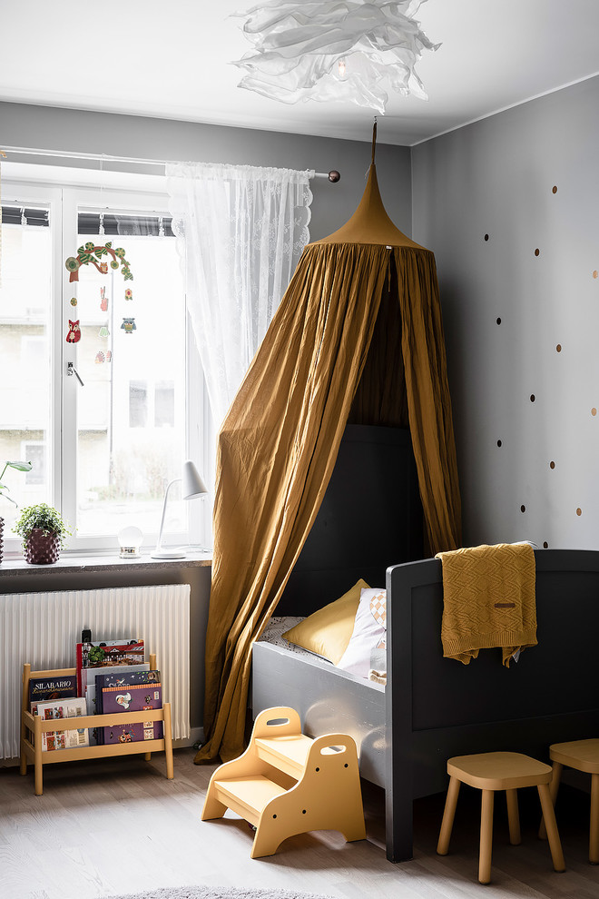 Nordisk inredning av ett mellanstort barnrum kombinerat med sovrum, med grå väggar och ljust trägolv