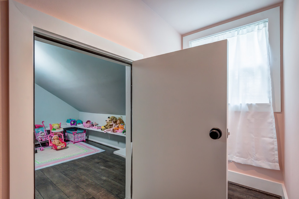 Cette image montre une chambre de fille de 1 à 3 ans traditionnelle de taille moyenne avec un mur bleu, sol en stratifié et un sol marron.