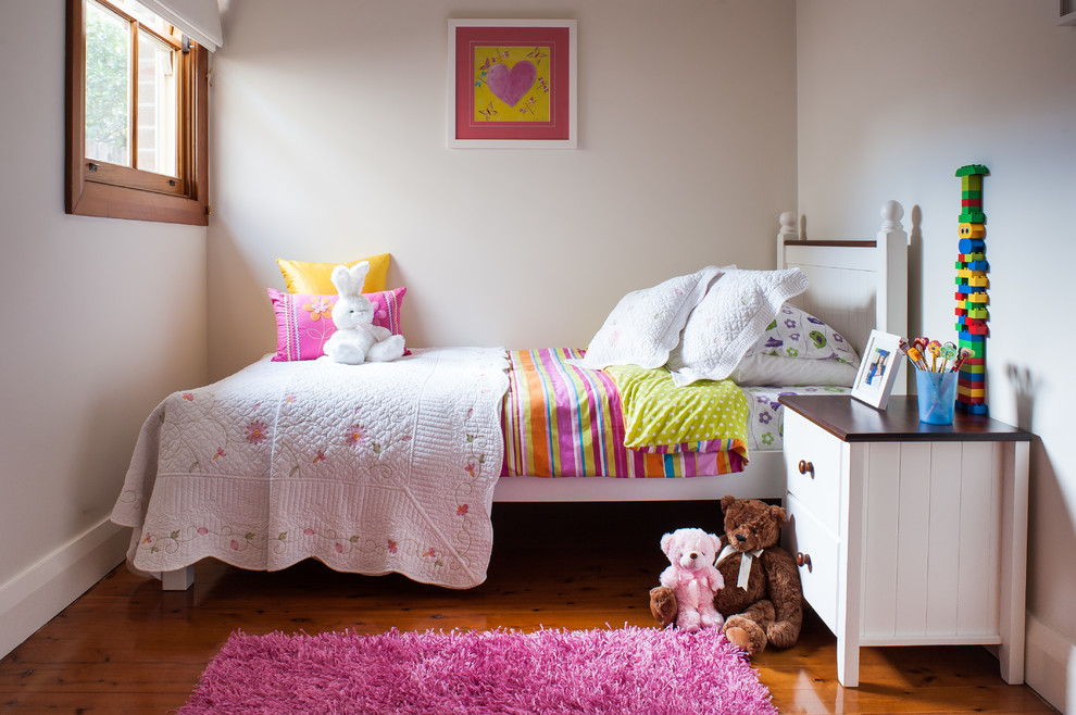 На фото: детская в классическом стиле с спальным местом, белыми стенами и паркетным полом среднего тона для ребенка от 4 до 10 лет, девочки с