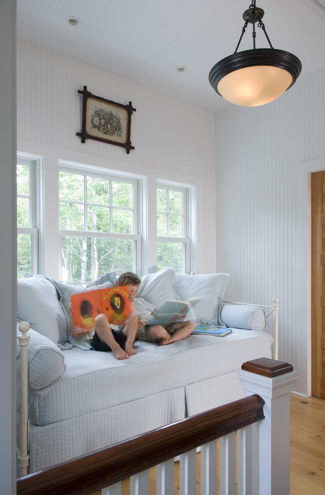 Design ideas for a traditional gender neutral kids' bedroom in Portland Maine with white walls and light hardwood flooring.