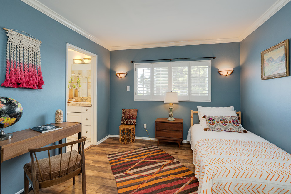 Diseño de dormitorio infantil tradicional renovado con paredes azules, suelo de madera en tonos medios y suelo marrón